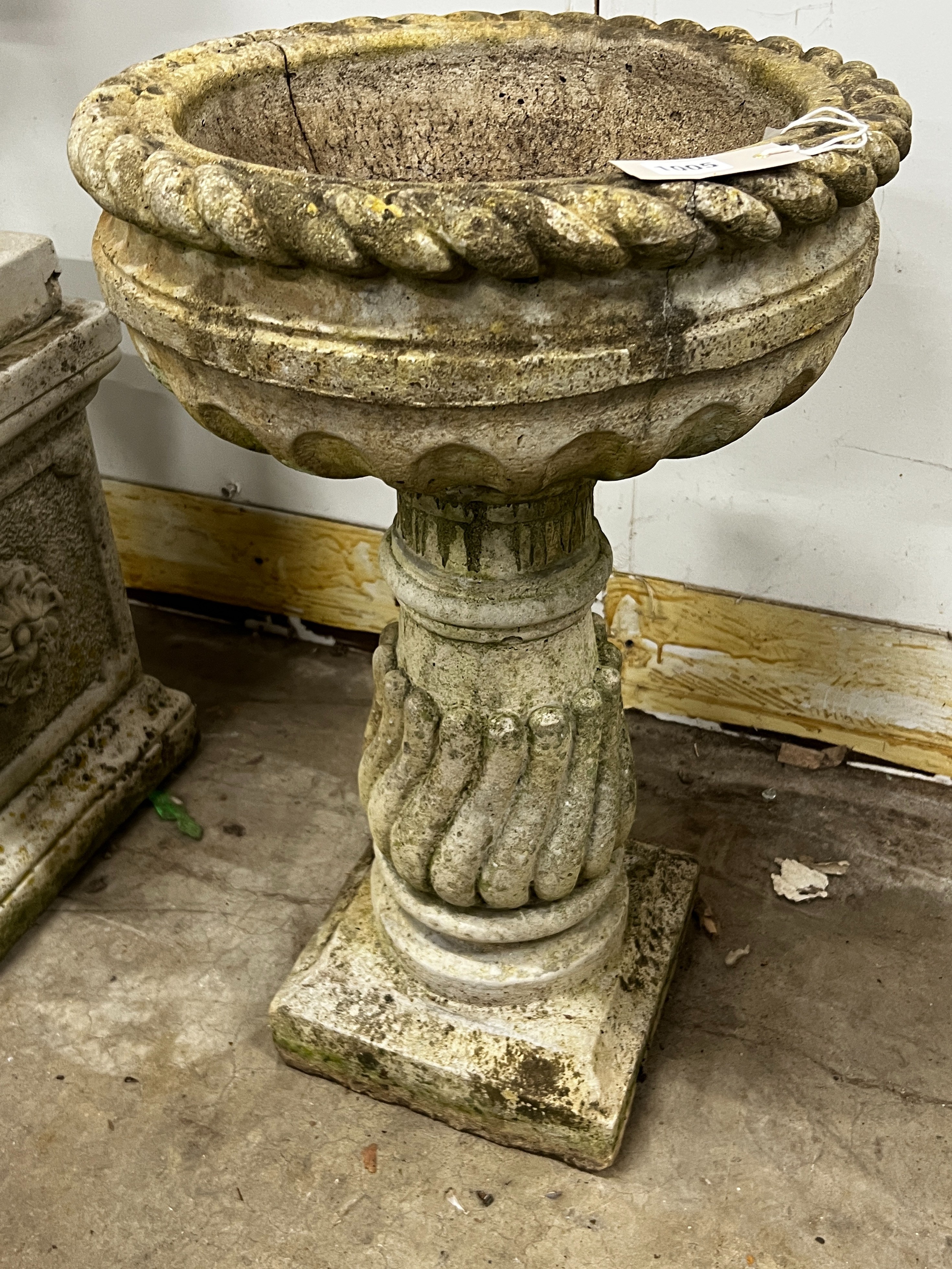 A circular reconstituted bird bath, diameter 40cm, height 65cm